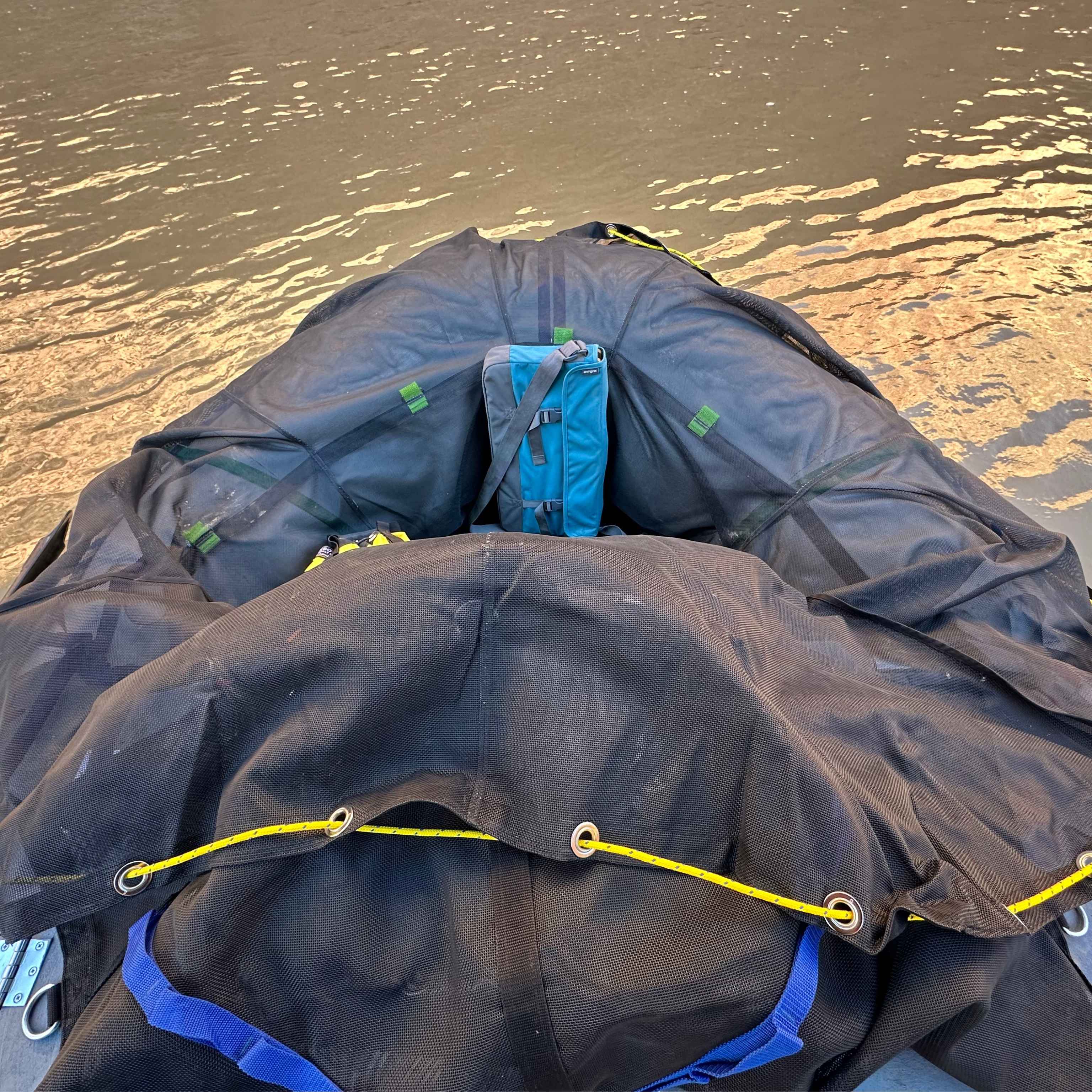 whitewater gear bag open and draped over raft tubes for easy loading