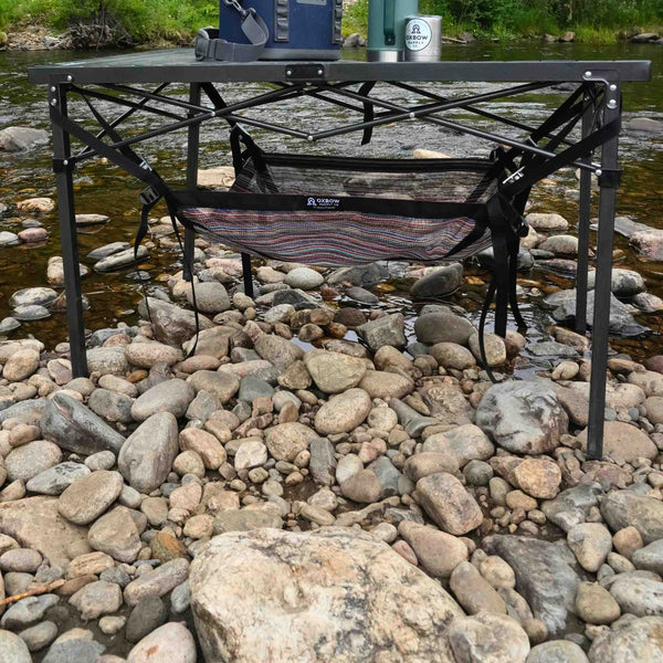 Under-table cargo sling attached to folding camp table