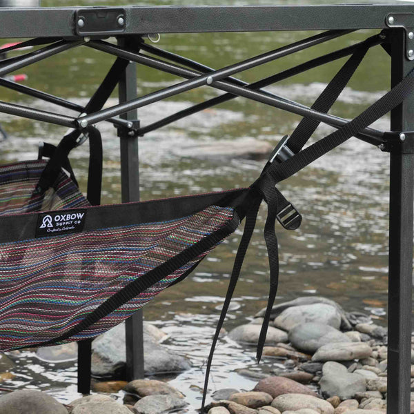 Camp table storage shelf keeping gear off the ground